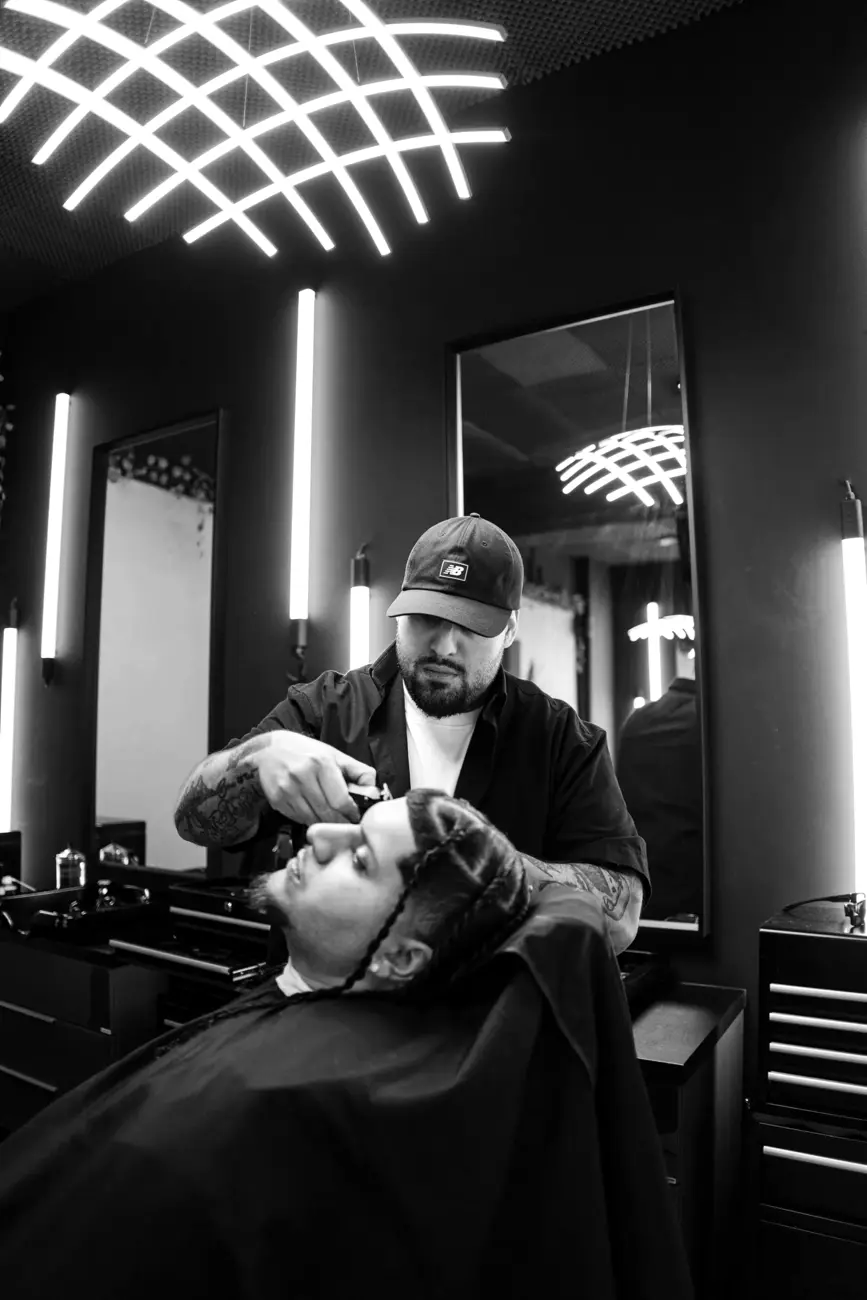 Barber strojčekom upravuje bradu klientovi
