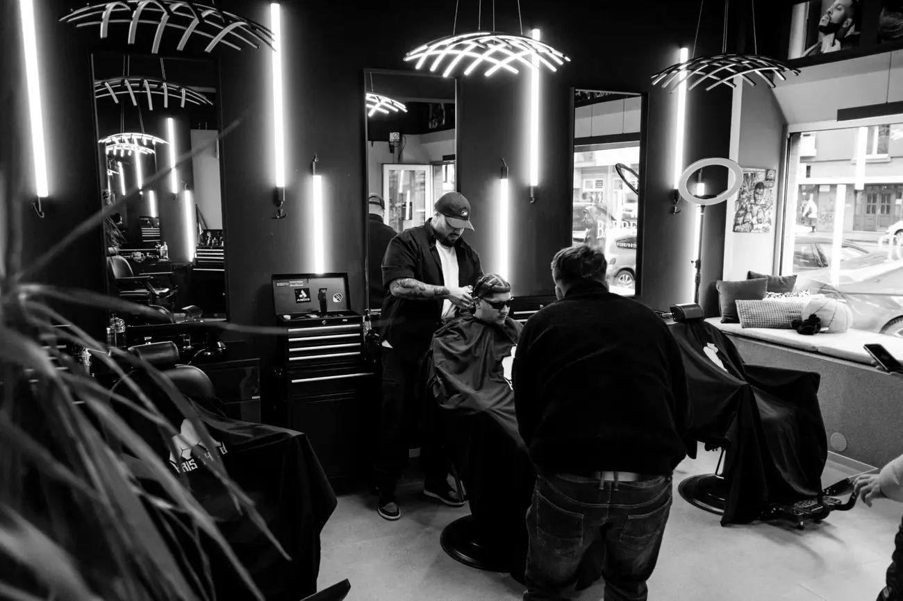 Barber strihá klienta s vrkočmi
