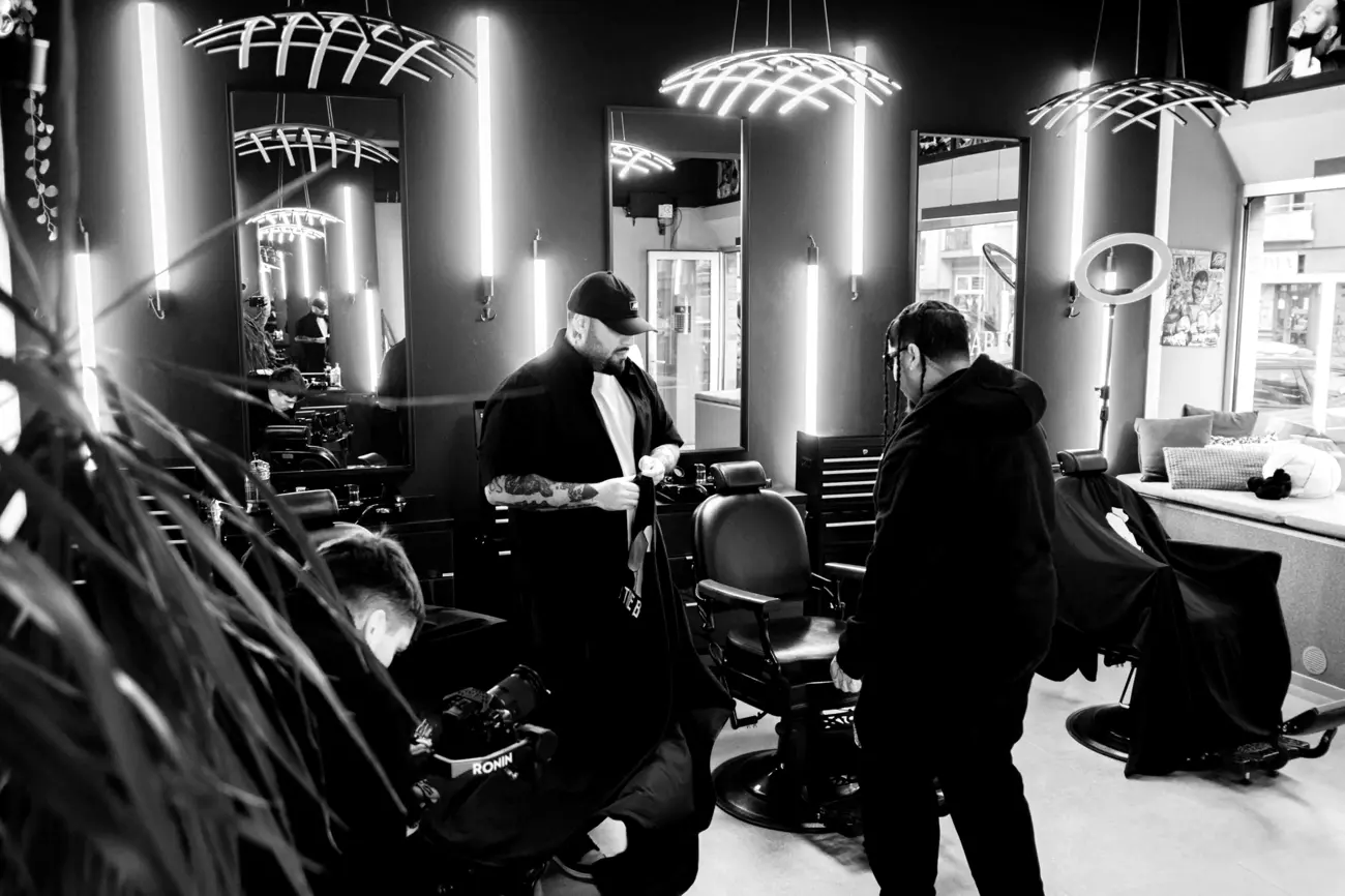 Barber pripravuje pelerínu pred holením